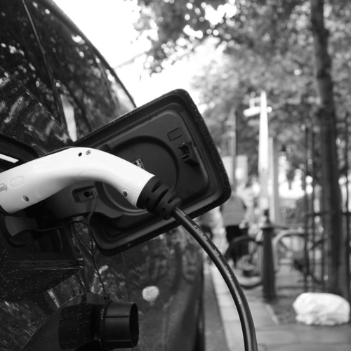 photo of electric vehicle charging plug connected to a car